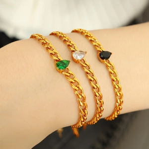 Elegantes Set aus goldfarbenen Panzerarmbändern mit tropfenförmigen Schmucksteinen in drei Farben