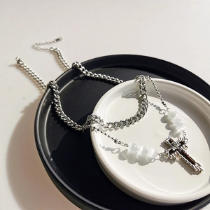 Silver layered cross pendant necklace with opal beads on a minimal display