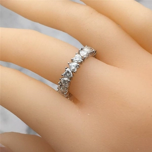 Sparkling silver heart-shaped pavé ring with white stones on a grey marble backdrop