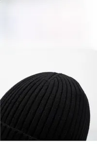 Close-up of black ribbed knit beanie showing thick texture and warm winter material