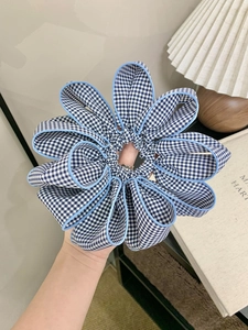 Detailed view of blue and white plaid lace scrunchie with layered floral design