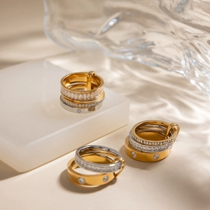Close-up of stacked gold and silver stainless steel rings with white zircon stones