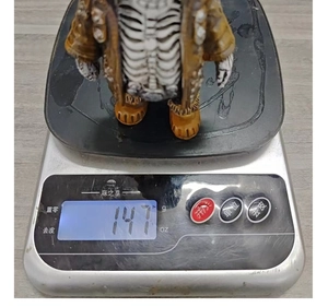 Halloween skeleton ornament weighing approximately 147g on a digital scale