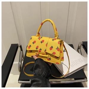 Detailopname van gele schoudertas met aardbeienprint en litchi-korrelige textuur