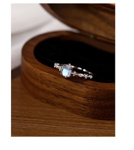 Macro shot of S925 sterling silver moonstone ring with crystals in a wooden jewelry box