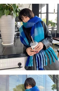 Detail of blue striped knit scarf with long tassels and fuzzy mohair texture