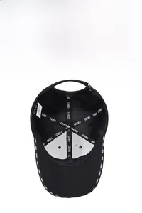 Detailed interior of black cotton baseball cap showing reinforced seams and breathable eyelets