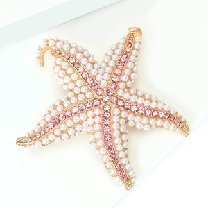 Detailed macro shot of alloy starfish brooch with white pearls and pink rhinestones