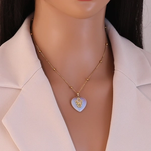 Detail of heart opal pendant necklace with gold figure inlay on a mannequin