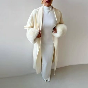Elegant white long coat with oversized faux fur cuffs paired with a matching knit dress