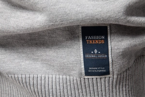 Gros plan sur la texture en maille de coton gris avec étiquette tissée tendance bleue