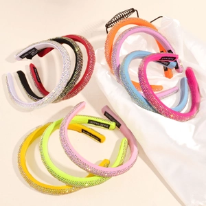 Macro shot of colorful rhinestone headbands featuring the Hand Made label on inner fabric