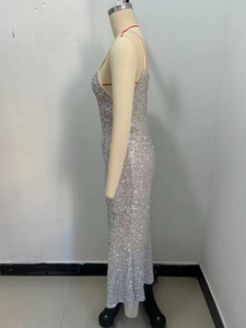 Détail de la silhouette latérale d'une robe longue à paillettes argentées brillantes
