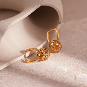 Detail of gold ear cuff earring with crystal-encrusted sphere in Maillard style