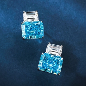 Macro view of blue cushion-cut and white rectangular gemstone earrings in silver setting