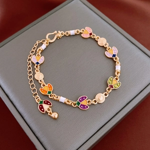 Detail of a gold-plated ladybug charm bracelet with colorful enamel insect pendants