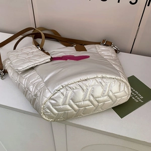 Detail der weißen Puffer-Tasche mit Steppmuster, rosa Herz und kleinem Geldbeutel
