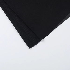 Gros plan sur le tissu en maille noire avec une texture de grille précise sur la robe