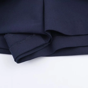 Dettaglio macro del tessuto blu scuro con cuciture fini e trama liscia della gonna