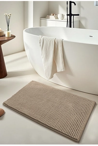 Macro detail of beige chenille bath mat with absorbent textured surface in modern bathroom