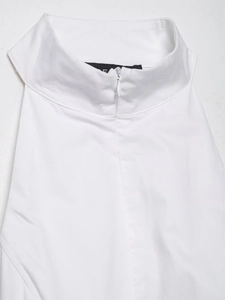 Détail du col montant et de la fermeture éclair invisible sur une robe blanche licou