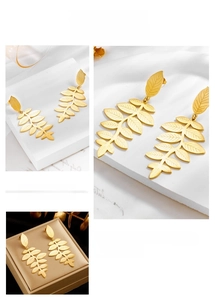 Detail of gold-plated leaf drop earrings showing intricate wheat grain textures