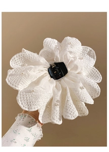 Detailed view of cream lace flower hair claw clip with pearls held in hand