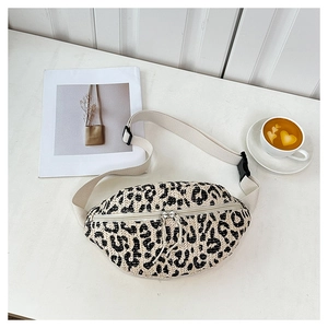 Flat lay of leopard print woven belt bag with beige strap and coffee on white table