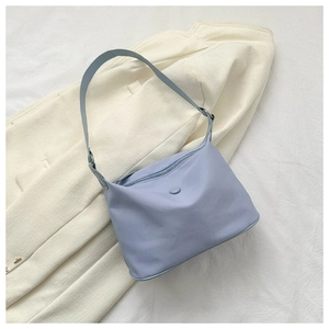 Detail of light blue crescent oxford shoulder bag with premium stitching and soft texture