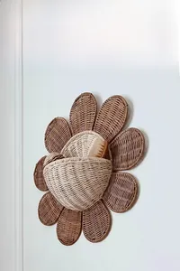 Detail of sunflower rattan wall basket showing dual-tone weave and a small storage pouch
