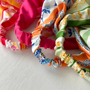 Detail of vibrant patterned satin elastic headbands with colorful floral prints