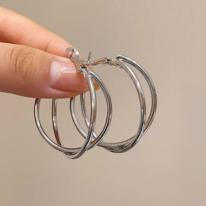 Detailed view of silver triple-hoop earrings featuring a layered minimalist metal design