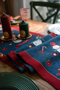 Detail of navy blue Christmas table runner with snowman patterns and Merry Christmas text