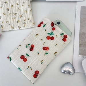 Dettaglio di pochette porta cellulare in seersucker con motivi a ciliegia e fiori