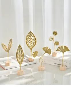 Detail of golden metal ginkgo leaf ornament with wood base for home decor