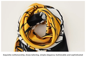 Detailed view of yellow and black abstract floral print on smooth silk texture scarf