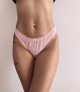 Detail of pink mesh lace thong featuring white bow embroidery and ruffle trim accents