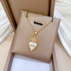 Detailed view of a gold heart crown pendant with sparkling crystals in a jewelry box