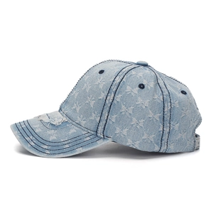 Detail of distressed light blue denim baseball cap with white butterfly prints and frayed brim