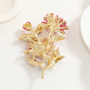 Detailed back view of pink enamel flower brooch showing the golden pin clasp and metal finish