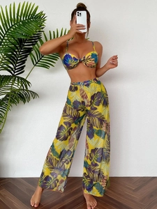 Detailed texture of tropical print bikini top and sheer mesh wide leg beach trousers