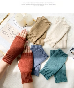 Flat lay of colorful knitted fingerless gloves in red, beige, and blue autumn tones