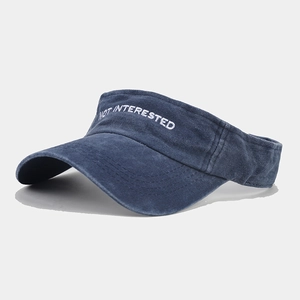 Detailed close-up of navy blue visor with NOT INTERESTED embroidery and vintage texture