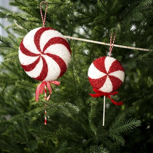 Glittery red and white swirl lollipop Christmas tree ornaments with festive bow decorations