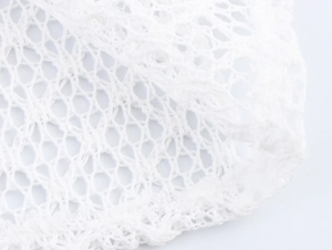 Detailed macro shot of white breathable mesh fabric and bubble sleeve texture