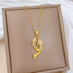 Detail shot of golden titanium steel dolphin pendant with pavé crystals on a jewelry box