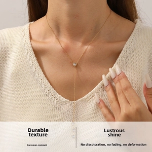 Detail of elegant gold Y-shaped necklace with heart zircon pendant on neck