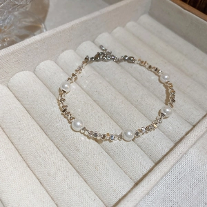 Détail d'un collier double rang avec perles blanches et perles argentées en boîte