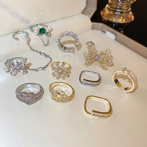 Close-up of pearl and zircon heart bow rings with emerald bracelet in a jewelry box