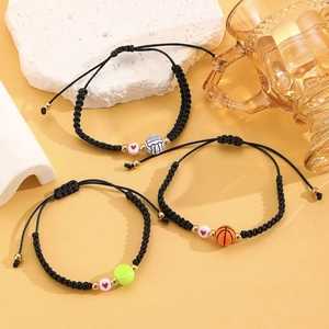 Detailed view of three adjustable braided bracelets with sports ball beads on a warm yellow background